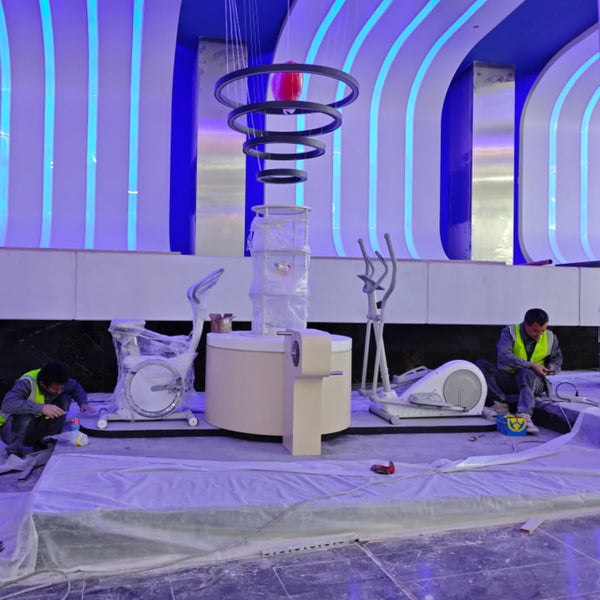 Technicians performing assembly and calibration on interactive science exhibits at a museum site.